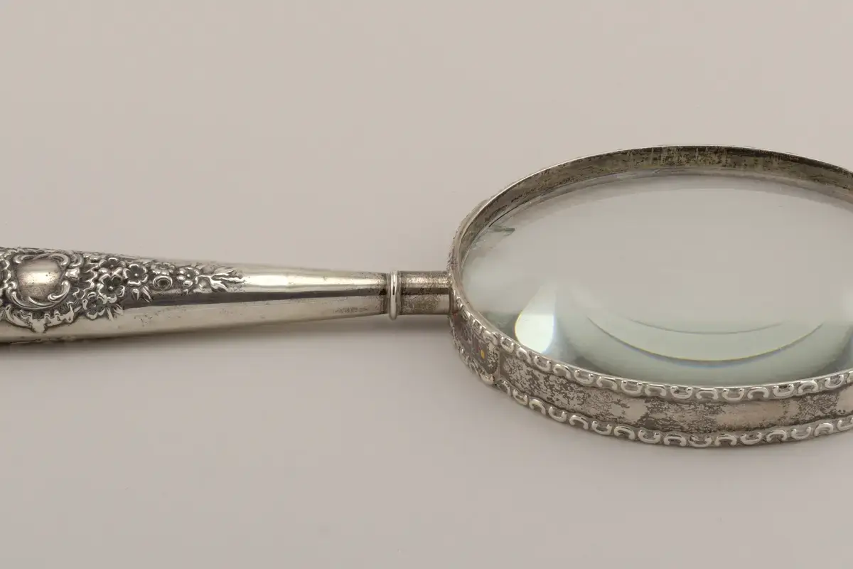 A late nineteenth-century silver magnifying glass photographed on a neutral background.